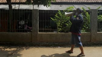 Warga memberi imbauan untuk menerapkan protokol kesehatan di Jalan Rawa Gula, Bantargebang, Bekasi, Jawa Barat, Minggu (27/6/2021). [Suara.com/Dian Latifah] 