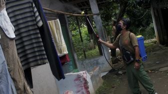 Warga menyemprotkan cairan disinfektan di Jalan Pangkalan 1, Bantargebang, Bekasi, Jawa Barat, Minggu (27/6/2021). [Suara.com/Dian Latifah] 