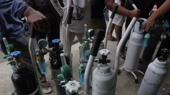 Sejumlah warga mengantre untuk mengisi ulang tabung oksigen di salah satu depot pengisian oksigen di kawasan Manggarai, Jakarta, Senin (28/6/2021). [Suara.com/Angga Budhiyanto]