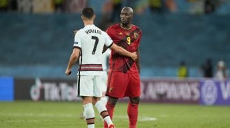 Pemain Belgia Romelu Lukaku bersalaman dengan Cristiano Ronaldo usai pertandingan dalam babak 16 besar Piala Eropa 2020 di La Cartuja Stadium, Seville, Spanyol, 28 Juni 2021 dini hari WIB. [AFP/Photo]