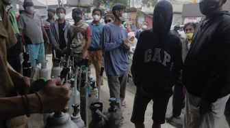 Sejumlah warga mengantre untuk mengisi ulang tabung oksigen di salah satu depot pengisian oksigen di kawasan Manggarai, Jakarta, Senin (28/6/2021). [Suara.com/Angga Budhiyanto]