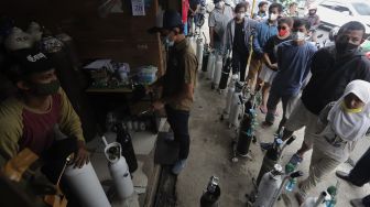 Pekerja mengisi ulang tabung oksigen di salah satu depot pengisian oksigen di kawasan Manggarai, Jakarta, Senin (28/6/2021). [Suara.com/Angga Budhiyanto]