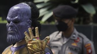 Massa aksi yang tergabung dalam serikat buruh dan masyarakat sipil mengenakan kostum penjahat Thanos saat melakukan aksi teatrikal di depan Gedung Merah Putih KPK, Jakarta, Senin (28/6/2021). [Suara.com/Angga Budhiyanto]