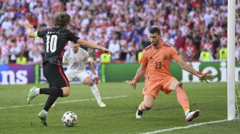 Penjaga gawang Spanyol Unai Simon (kanan) bersiap untuk memblok tembakan ke gawang oleh gelandang Kroasia Luka Modric selama pertandingan sepak bola babak 16 besar UEFA EURO 2020 antara Kroasia dan Spanyol di Stadion Parken, Kopenhagen, pada (28/6/2021). [STUART FRANKLIN / POOL / AFP]