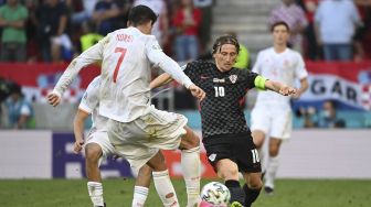 Pemain depan Spanyol Alvaro Morata bersaing dengan gelandang Kroasia Luka Modric selama pertandingan sepak bola babak 16 besar UEFA EURO 2020 antara Kroasia dan Spanyol di Stadion Parken, Kopenhagen, pada (28/6/2021). [Jonathan NACKSTRAND / POOL / AFP]