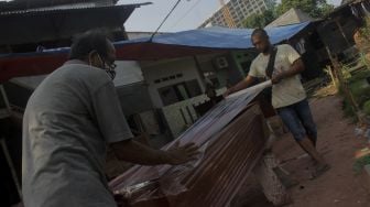 Pekerja menyelesaikan pembuatan peti mati di Yayasan Sahabat Duka, TPU Pondok Kelapa, Jakarta, Selasa (29/6/2021). [Suara.com/Dian Latifah]