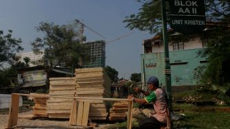 Pekerja menyelesaikan pembuatan peti mati di Yayasan Sahabat Duka, TPU Pondok Kelapa, Jakarta, Selasa (29/6/2021). [Suara.com/Dian Latifah]