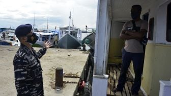 Anggota TNI Angkatan Laut mengajak seorang nelayan untuk divaksin di Pelabuhan Paotere, Makassar, Sulawesi Selatan, Selasa (29/6/2021). [ANTARA FOTO/Abriawan Abhe]