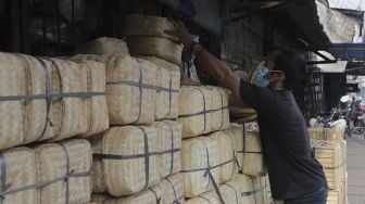 Pedagang merapikan besek dari anyaman bambu di Pasar Jatinegara, Jakarta, Rabu (30/6/2021). [Suara.com/Angga Budhiyanto]