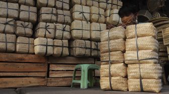 Pedagang menata besek dari anyaman bambu di Pasar Jatinegara, Jakarta, Rabu (30/6/2021). [Suara.com/Angga Budhiyanto]