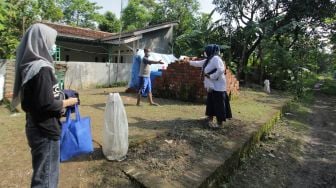 Pengurus RT memberikan masker kepada salah satu warga terkonfirmasi positif COVID-19 saat menjalani isolasi mandiri di desa Lohbener, Indramayu, Jawa Barat, Rabu (30/6/2021). ANTARA FOTO/Dedhez Anggara