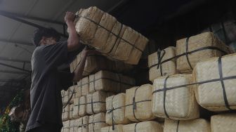 Pedagang merapikan besek dari anyaman bambu di Pasar Jatinegara, Jakarta, Rabu (30/6/2021). [Suara.com/Angga Budhiyanto]