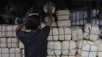 Pedagang merapikan besek dari anyaman bambu di Pasar Jatinegara, Jakarta, Rabu (30/6/2021). [Suara.com/Angga Budhiyanto]