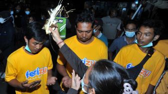 Sejumlah penumpang selamat KMP Yunice asal Bali menjalani ritual setibanya di Pelabuhan Gilimanuk, Jembrana, Bali, Rabu (30/6/2021) dini hari.  ANTARA FOTO/Fikri Yusuf