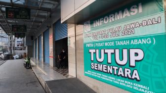 Spanduk berisi informasi penutupan pasar selama PPKM Darurat di Pasar Tanah Abang, Jakarta Pusat, Sabtu (3/7/2021). [Suara.com/Alfian Winanto]