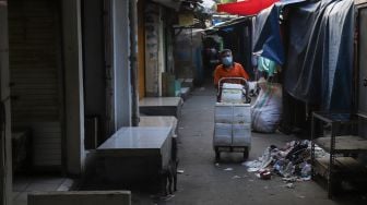 Pedagang membereskan dagangannya di Pasar Tanah Abang, Jakarta Pusat, Sabtu (3/7/2021). [Suara.com/Alfian Winanto]