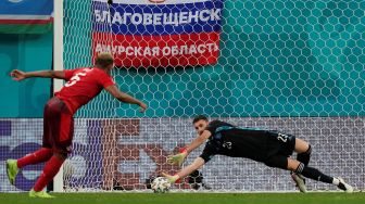 Penjaga gawang Spanyol Unai Simon (kanan) menyelamatkan tendangan bek Swiss Manuel Akanji saat adu penalti di akhir pertandingan sepak bola perempat final EURO 2020 antara Swiss melawan Spanyol di Stadion Saint Petersburg, Jumat (2/6).Dmitri Lovetsky / POOL / AFP