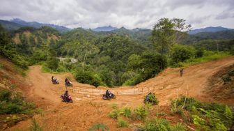 Pengendara melintasi jalan yang rusak tertutup tanah longsor di Desa Hinas Kanan, Kabupaten Hulu Sungai Tengah, Kalimantan Selatan, Minggu (4/7/2021). [ANTARA FOTO/Bayu Pratama S]