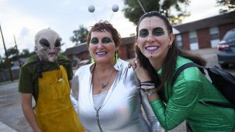 Warga mengenakan kostum alien selama Festival UFO di Roswell, New Mexico, pada (2/7/2021). [Patrick T. FALLON / AFP]