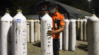 Petugas mengelompokkan tabung oksigen sesuai rumah sakit di Posko Darurat Oxygen Rescue di kawasan Monumen Nasional (Monas), Jakarta Pusat, Selasa (6/7/2021). [Suara.com/Alfian Winanto]