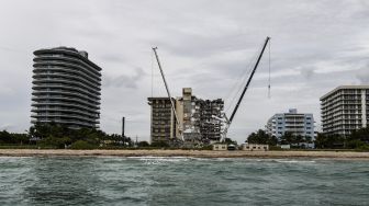 Tim SAR mencari kemungkinan korban selamat di gedung kondominium Champlain Towers South yang sebagian runtuh, di Surfside, Florida, pada (29/6/2021). [CHANDAN KHANNA / AFP]