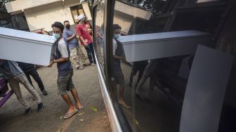 Pekerja mengangkut peti jenazah ke dalam ambulans untuk didistribusikan di TPU Petamburan, Jakarta Pusat, Selasa (6/7/2021). ANTARA FOTO/M Risyal Hidayat