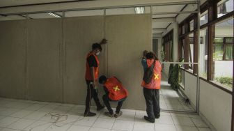 Pekerja menyelesaikan persiapan RS Darurat COVID-19 di Kompleks Asrama Haji, Pondok Gede, Jakarta, Rabu (7/7/2021). ANTARA FOTO/Asprilla Dwi Adha