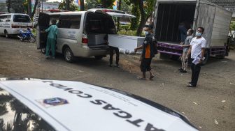 Pekerja mengangkut peti jenazah ke dalam ambulans untuk didistribusikan di TPU Petamburan, Jakarta Pusat, Selasa (6/7/2021). ANTARA FOTO/M Risyal Hidayat