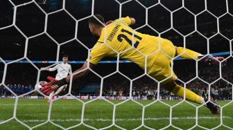 Penjaga gawang Italia, Gianluigi Donnarumma menggagalkan eksekusi striker Spanyol Alvaro Morata, dalam adu penalti di semifinal UEFA EURO 2020 antara Italia vs Spanyol, di Stadion Wembley London, Inggris, Rabu (7/7) dini hari WIB.  [Photo/AFP]