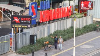 Warga melintas di depan Plaza Kenari Mas di kawasan Senen, Jakarta Pusat, Kamis (8/7/2021). [Suara.com/Alfian Winanto]