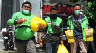 Sejumlah pengendara ojek membawa paket bahan pokok usai mengikuti vaksinasi COVID-19 di Bele Li Mbui, Kota Gorontalo, Gorontalo, Kamis (8/7/2021).  ANTARA FOTO/Adiwinata Solihin