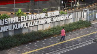 Warga melintas di depan Plaza Kenari Mas di kawasan Senen, Jakarta Pusat, Kamis (8/7/2021). [Suara.com/Alfian Winanto]