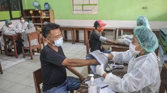 Sejumlah warga antre menjalani pemeriksaan kesehatan sebelum mendapatkan vaksin COVID-19 di Yayasan Pendidikan Islam Al-Mahbubiyah, Jakarta Selatan, Rabu (7/7/2021). ANTARA FOTO/M Risyal Hidayat