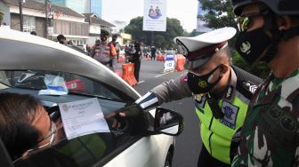 Pengendara menunjukkan Surat Tanda Registrasi Pekerja (STRP) kepada petugas di pos penyekatan pembatasan mobilitas masyarakat pada PPKM Darurat di wilayah perbatasan menuju Jakarta di Jalan Margonda, Depok, Jawa Barat, Jumat (9/7/2021). ANTARA FOTO/Indrianto Eko Suwarso