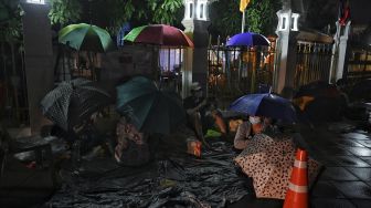 Warga tertidur saat mereka mengantre semalaman untuk swab test COVID-19 gratis di Wat Phra Sri Mahathat Woramahawihan, Bangkok, pada (9/7/2021) dini hari. [Lillian SUWANRUMPHA / AFP]