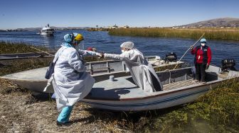 Petugas kesehatan tiba di Pulau Uros untuk menyuntik warga dengan vaksin COVID-19 Sinopharm di Danau Titicaca, Puno, Peru, pada (7/7/2021). [Carlos MAMANI / AFP]