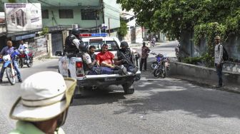 Dua pria, yang dituduh terlibat dalam pembunuhan Presiden Jovenel Moise, diangkut menuju kantor Polisi Petionville dengan mobil polisi di Port au Prince, Haiti, pada (8/7/2021). [Valerie Baeriswyl / AFP]