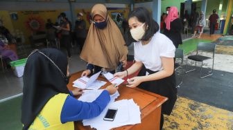 Warga usai menjalani vaksinasi di RPTRA Kalijodo, Jakarta Barat, Jumat (9/7/2021). [Suara.com/Alfian Winanto]