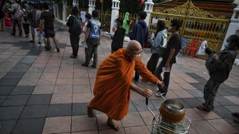 Warga mengantre untuk mengambil tiket swab test COVID-19 gratis di Wat Phra Sri Mahathat Woramahawihan, Bangkok, pada (9/7/2021). [Lillian SUWANRUMPHA / AFP]