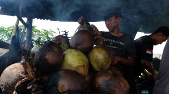 Pedagang membakar kelapa muda di Kendal, Jawa Tengah, Kamis (8/7/2021). ANTARA FOTO/Anis Efizudin