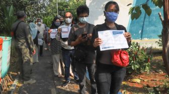 Warga mengantri untuk menjalani vaksinasi di RPTRA Kalijodo, Jakarta Barat, Jumat (9/7/2021). [Suara.com/Alfian Winanto]