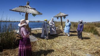 Petugas kesehatan tiba di Pulau Uros untuk menyuntik warga dengan vaksin COVID-19 Sinopharm di Danau Titicaca, Puno, Peru, pada (7/7/2021). [Carlos MAMANI / AFP]