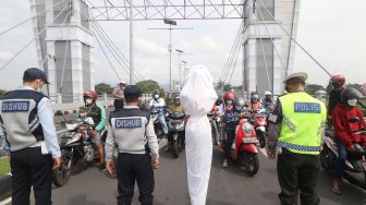 Anggota Satlantas Polres Kediri Kota bersama Dinas Perhubungan mengajak pengguna jalan untuk mengheningkan cipta bagi korban COVID-19 di Kota Kediri, Jawa Timur, Sabtu (10/7/2021). ANTARA FOTO/Prasetia Fauzani
