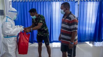 Pasien yang terkonfirmasi positif COVID-19 dengan gejala ringan mengambil hidangan makan di ruang isolasi di Rumah Sakit Darurat Pangkalan Marinir Jakarta, Sabtu (10/7/2021). [ANTARA FOTO/M Risyal Hidayat]