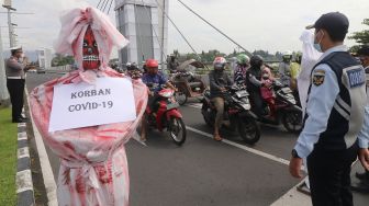 Anggota Satlantas Polres Kediri Kota bersama Dinas Perhubungan mengajak pengguna jalan untuk mengheningkan cipta bagi korban COVID-19 di Kota Kediri, Jawa Timur, Sabtu (10/7/2021). ANTARA FOTO/Prasetia Fauzani
