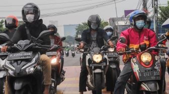 Pengendara motor berhenti sejenak untuk mengheningkan cipta di kawasan Cilandak, Jakarta Selatan, Sabtu (10/7/2021). [Suara.com/Alfian Winanto]