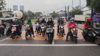 Pengendara motor berhenti sejenak untuk mengheningkan cipta di kawasan Cilandak, Jakarta Selatan, Sabtu (10/7/2021). [Suara.com/Alfian Winanto]