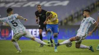 Pemain Brazil Everton (tengah) dijaga oleh pemain Argentina Leandro Paredes (kiri) dan Nicolas Otamendi selama pertandingan final turnamen sepak bola Copa America Conmebol 2021 di Stadion Maracana, Rio de Janeiro, Brasil, pada (10/7/2021). [CARL DE SOUZA / AFP]