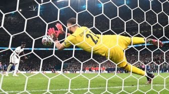 Gelandang Inggris Bukayo Saka gagal mencetak gol melewati kiper Italia Gianluigi Donnarumma (kiri) dalam adu penalti selama pertandingan sepak bola final EURO 2020 antara Italia melawan Inggris Stadion Wembley, London, Senin (12/7) dini hari WIB.  Paul ELLIS / AFP