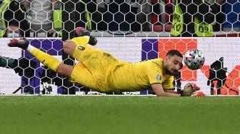 Gelandang Inggris Bukayo Saka gagal mencetak gol melewati kiper Italia Gianluigi Donnarumma (kiri) dalam adu penalti selama pertandingan sepak bola final EURO 2020 antara Italia melawan Inggris Stadion Wembley, London, Senin (12/7) dini hari WIB.  Paul ELLIS / AFP